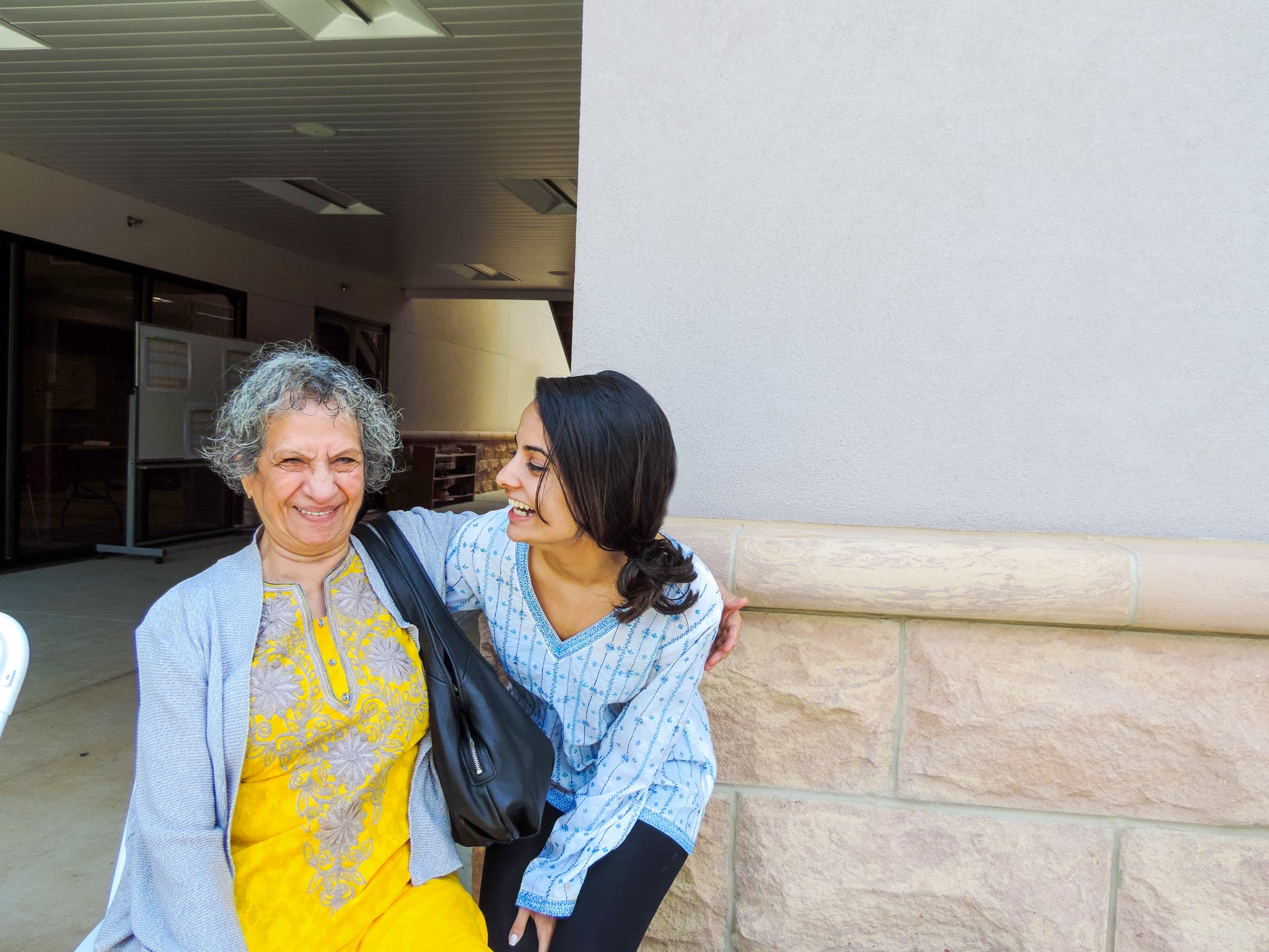 A member laughing with a staff member outside the center