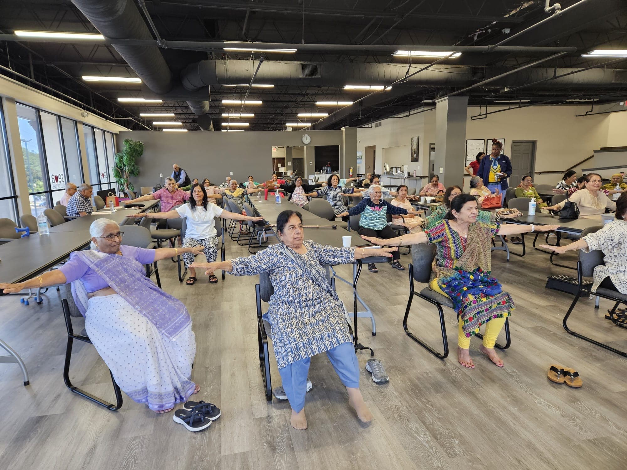 Members of the Seva Senior Day Center in a seated chair yoga class