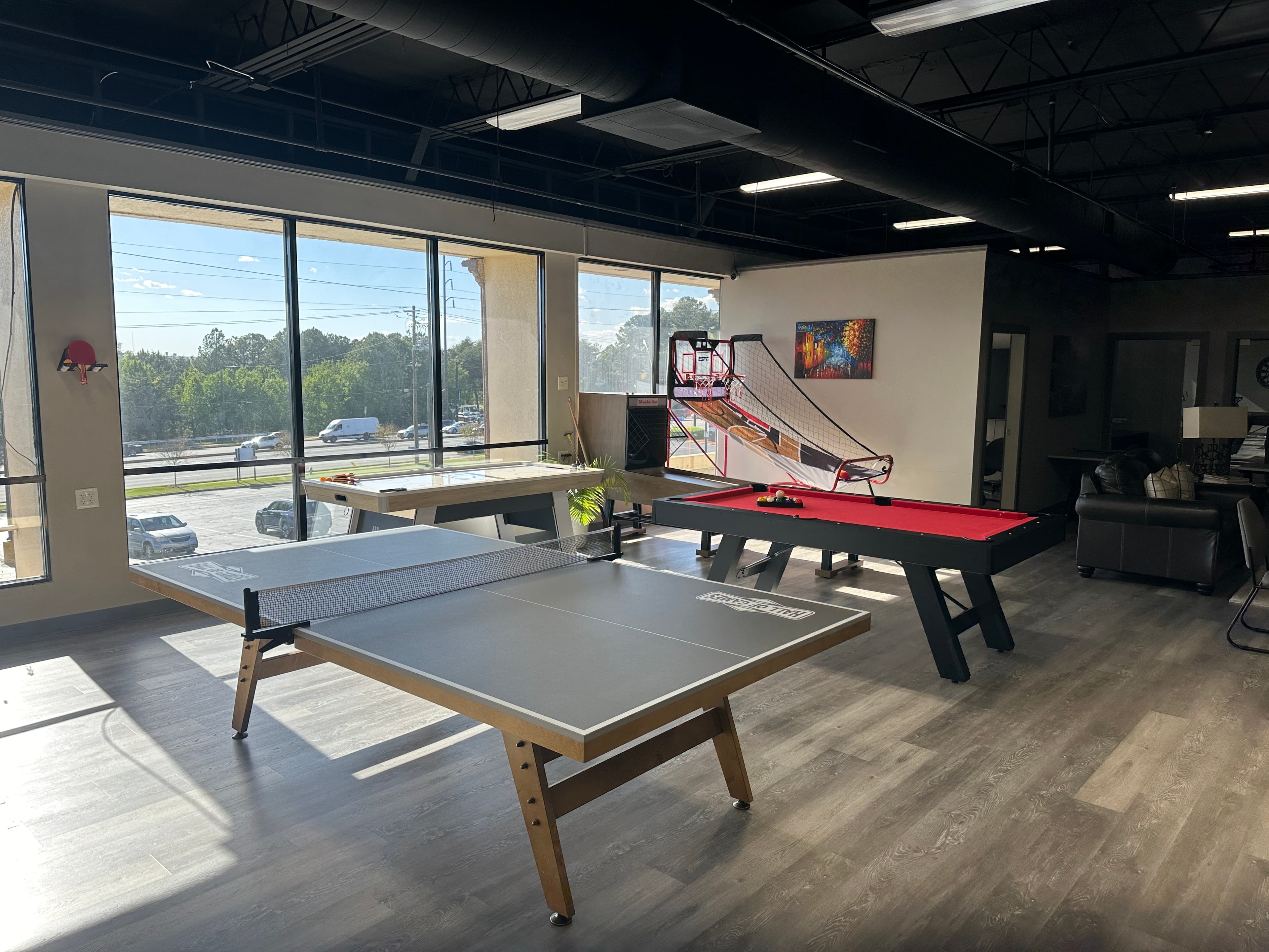 The games room with a pool table by tall windows